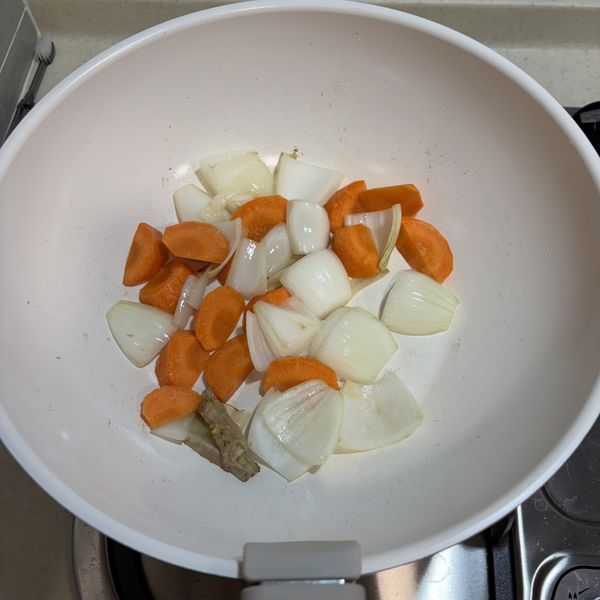 熱鍋後放點油，先加入薑片爆香及洋蔥翻炒，再加紅蘿蔔拌炒1-2分鐘。（時間夠的話可以等洋蔥呈半透明再加紅蘿蔔）