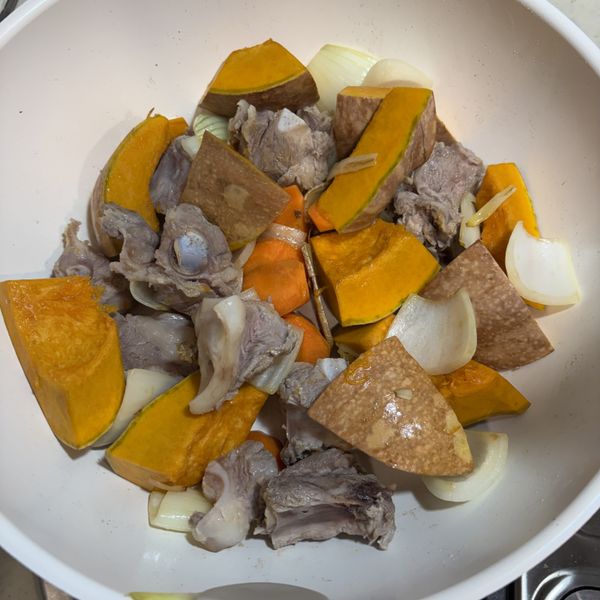 再加入南瓜及排骨肉拌炒，此時可加入一小匙鹽巴拌炒。