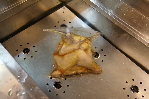 把裝進真空袋且醃漬好的半雞隔水加熱。