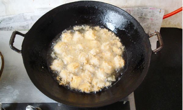 油鍋燒至五～六成熱，投入裹好澱粉的嫩豆腐，待豆腐浮起油面，成金黃色時撈出、瀝油，擺放在大碗內；