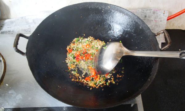 炒鍋加沙拉油燒至五成熱，放入蔥花、薑末和蒜末炒香，再放入小紅尖椒翻炒約10秒；