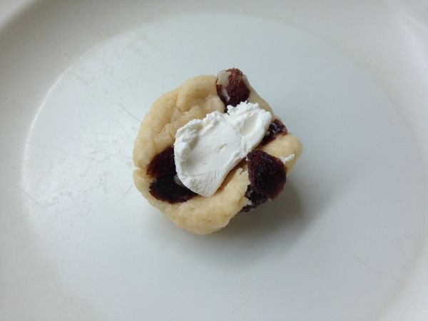 取約20~25公克的麵團搓成球狀後壓扁，挖適量的cream cheese在中間。