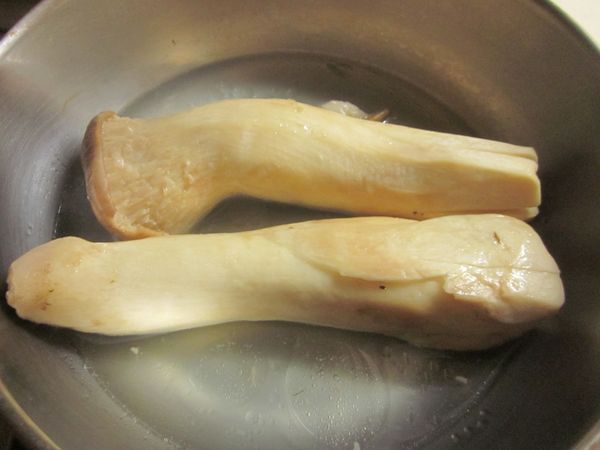 取一鍋子放入1杯水及一小匙油,將杏鮑菇末端劃十字入鍋煮至滾,撈起切成塊狀