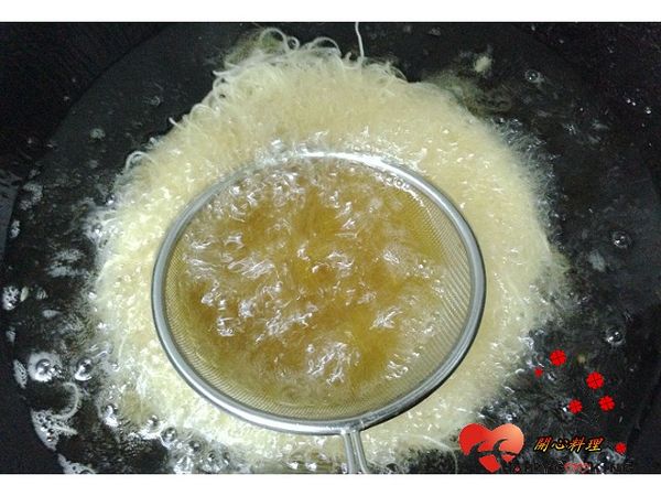 放入高溫油鍋中用大火炸,上面的勺子要壓至定型才能放開,炸至酥脆