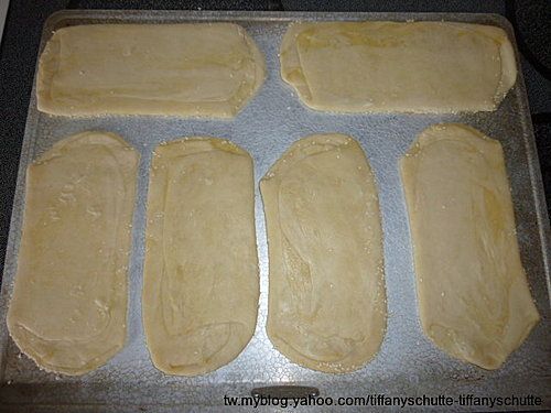 將燒餅芝麻面朝下間隔整齊排放在烤盤上