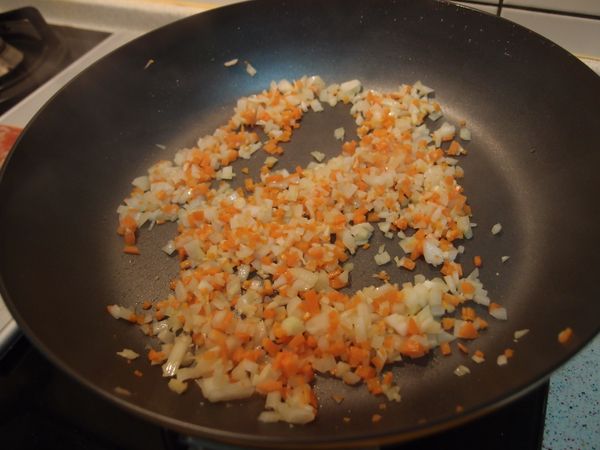 熱鍋熱油，將洋蔥和紅蘿蔔炒至軟化。
(使用樂扣樂扣E-COOK系列彩繪炒鍋，
內層以不沾性複合金表面處理，
只需要用非常少量的油脂。)