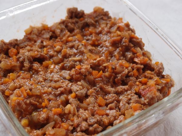 將煮好的肉醬鋪在保鮮盒中。