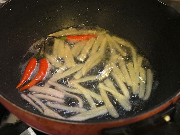 另取一平底鍋, 放入一大匙食用油, 薑絲, 紅辣椒小火爆香...