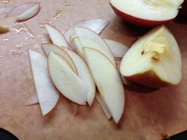 蘋果表面清洗乾淨，切成四份，去蒂去核。然後切成薄片，盡量切薄，約0.2cm厚。這樣吃起來會比較脆，而且烤的時間會快一點。