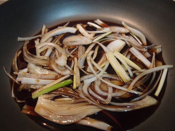 [醬汁]倒入鍋中，放洋蔥絲和蔥絲