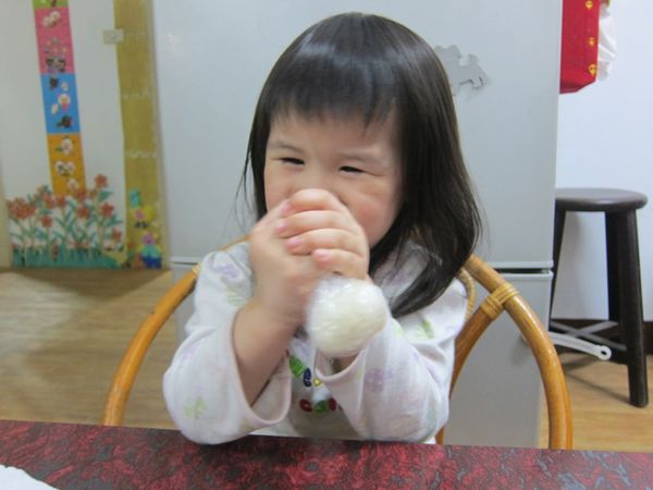 連同塑膠袋抓起，包裹抓緊成圓形飯糰。