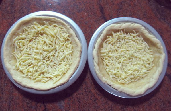 在烤好的派皮上放上起司，均勻佈滿。