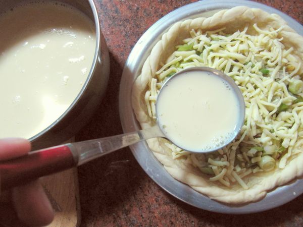 將蛋打入一鍋用打蛋器攪拌均勻後，加入牛奶拌勻，用大湯匙勺入鋪好的派至8、9分滿。