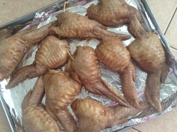 將油飯塞入雞翅內，並用牙籤固定開口處。烤箱400F，入烤箱前用醃料的汁塗抹雞翅表面，烤十分鐘後翻面，刷醬汁，再烤十分鐘。