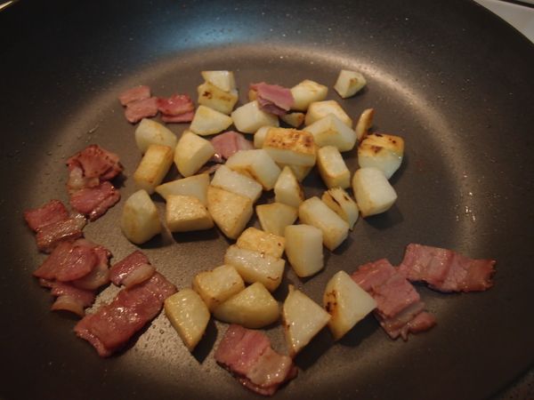在鍋中放入培根，煎出培根香氣，加入剩下的蘋果塊，以鹽和黑胡椒調味。