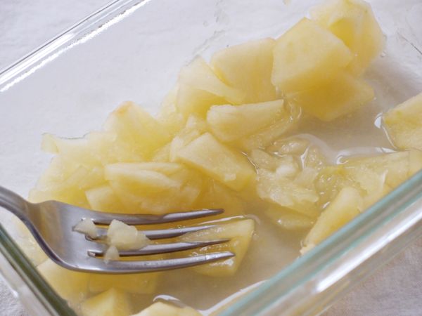 在煎馬鈴薯的同時，將蘋果去皮切小塊，把3/4的蘋果塊和[調味料A]放入玻璃保鮮盒中，以900w微波2-3分鐘，將其壓碎備用。