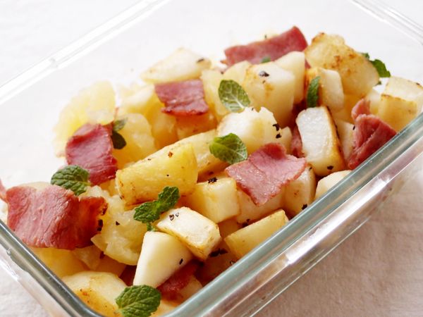 在盛裝蘋果泥的盒中，裝入煎炒好的食材，綴以薄荷葉。