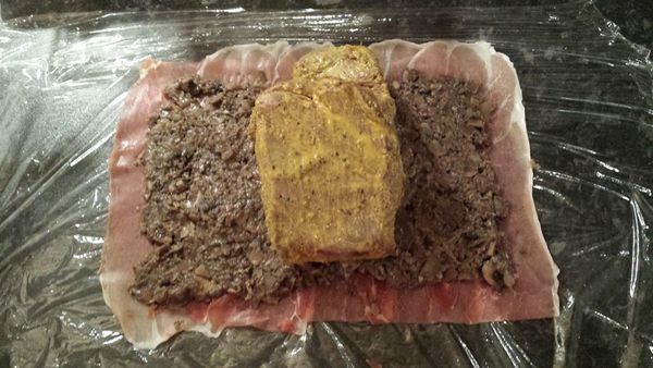 保鮮膜鋪平，上面鋪巴馬火腿，火腿之間要重疊，將蘑菇泥搽上去，將牛柳放上中間，隔保鮮膜將牛柳卷緊，雪15分鐘。