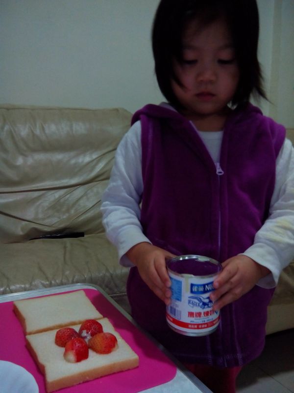 把草莓及煉乳放入吐司中間