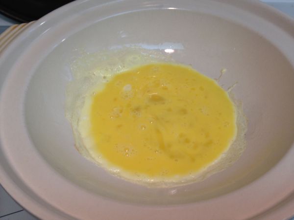 取一小砂鍋，四周先刷上一層薄薄的油後，開火加熱到鍋子很燙再倒入打散的蛋液。(蛋汁一下四周會馬上凝固的狀態)，再用筷子稍稍拌一下。