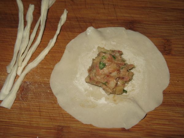 餃皮邊邊略桿薄成荷葉邊備用。
餃皮包餡料。