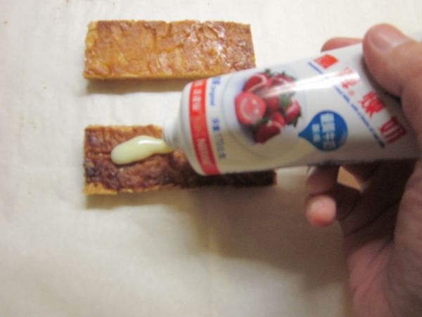 二片酥皮各擠上鷹牌煉奶,再擠上鮮奶油,放上草莓