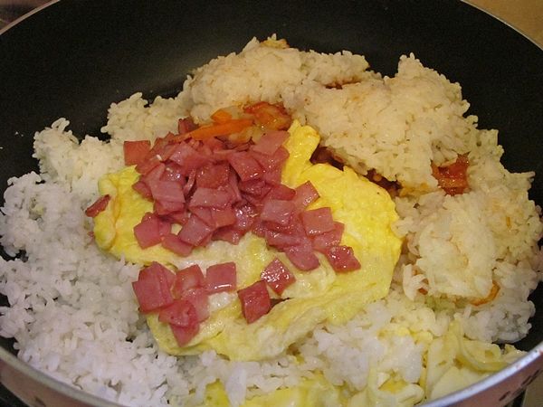 倒入白飯, 火腿, 雞蛋~將所有材料翻炒均勻~試味道?(可依家人習慣的口味做調整, 我又延著鍋邊加了些醬油進來, 並撒了些黑胡椒增添味覺的層次)