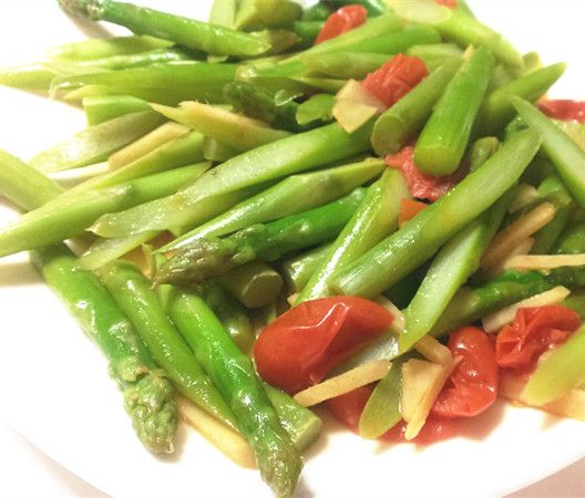 開中火倒油,薑絲稍微爆香,蘆筍根部先下鍋加水,蓋鍋蓋悶煮, 蘆筍半熟後, 把剩下較嫩的蘆筍跟小番茄一起下鍋(水不夠再加一點)悶煮到熟, 加一點鹽巴拌炒, 就可以準備起鍋。