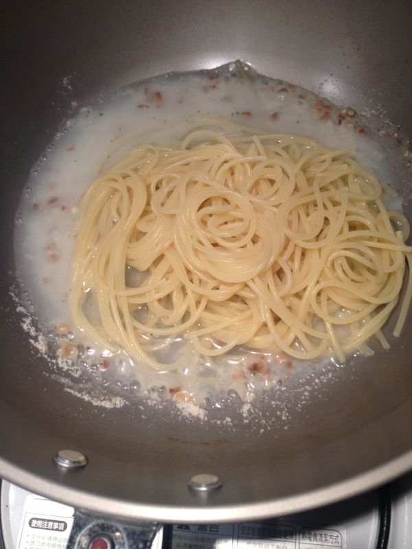 別忘了此時是提早兩分鐘離水的麵，所以還沒熟。倒入加了濃湯粉的炒鍋裡繼續煮，水不夠就再加煮麵水！