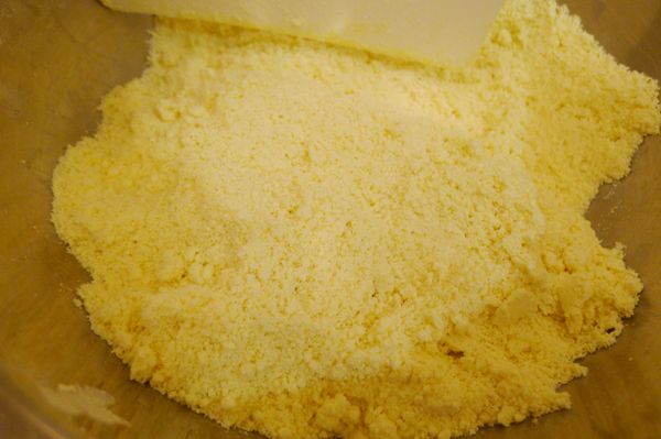 將冷藏中預先切成1公分小丁的奶油取出放進攪拌盆，以刮切拌混和均勻，再以手指將奶油&amp;粉類搓揉捏拌成鬆散顆粒狀