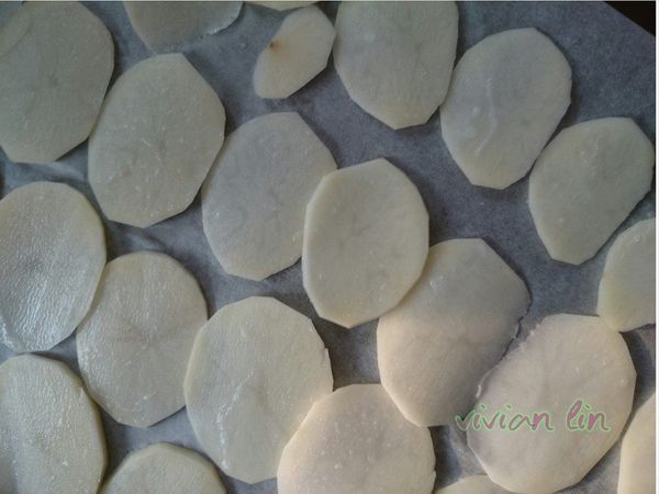 在烤盤鋪上烘培紙.把馬鈴薯片均勻的鋪上  不要相疊一起