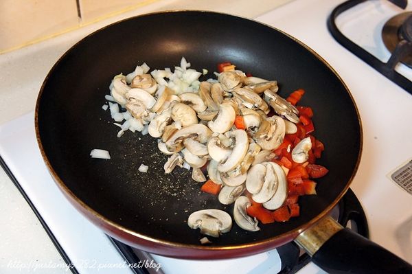 拿出平底鍋開中小火，灑上義式香料以及羅勒葉，倒入剛備好的蘑菇、洋蔥及甜椒拌炒