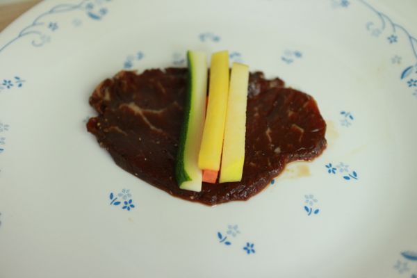 醃好的肉片攤平，放上條狀蔬果，蔬果也可依個人喜好做改變。