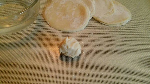 先拿一塊餃皮沾點水，捏一下。

再加入另一塊餃皮(一樣沾些水)，捏成團但是先不要搓揉它。