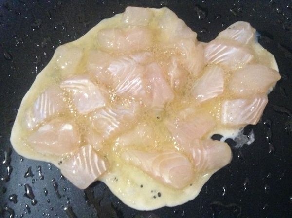 多利魚塊與蛋白一併放進炒鍋中。
待魚塊半熟後再翻炒。