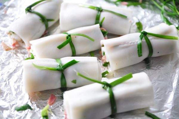 將粿仔片輕輕的緊緊的捲起來，並用韭菜做繩繞圈打結(新鮮韭菜較脆打結易斷，可將韭菜川燙變軟增加韌度)