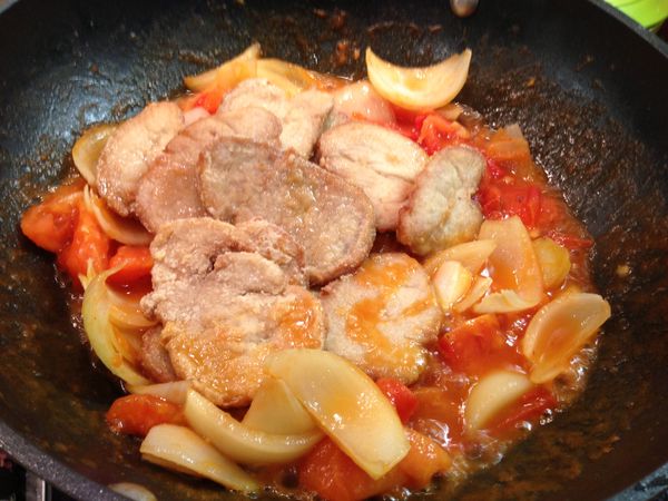 待番茄煮軟後，放入已炸好的豬排繼續拌炒。