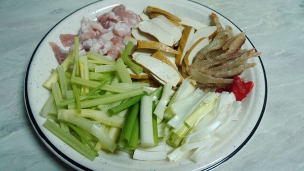 芹菜切段。蒜苗斜切片。辣椒斜切片。蝦乾泡水（水保留）。五花肉切條狀。