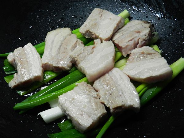 肉片煎好後夾出，擺上蔥段後，再放上肉片