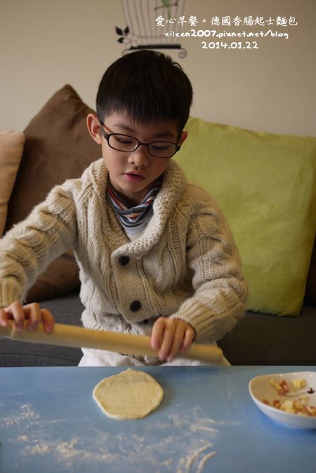 醒好的麵糰用擀麵棍擀壓成為圓形麵皮，中間放上適量香腸和起士片，收口捏緊滾圓，並封口朝下放在鋪好烘培紙的烤盤上，準備進行第二次發酵。