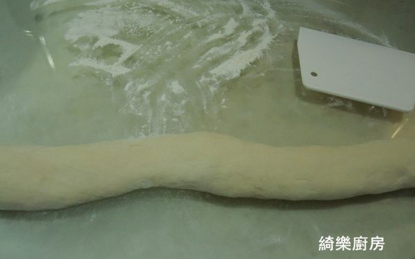 沾手粉把麵糰裡面的空氣擠出來後,搓成長條狀