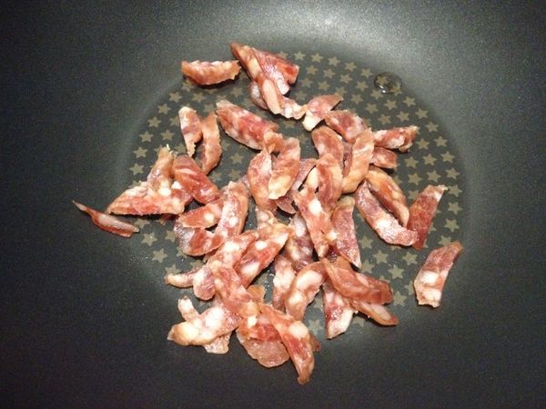 熱鍋下香腸煸炒出油脂，至焦香熟透後起鍋放涼。