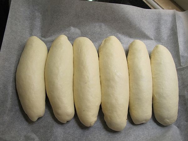 烤盤鋪上烘培紙, (烘培紙的長度蓋過烤盤)將麵團整齊緊靠排放...