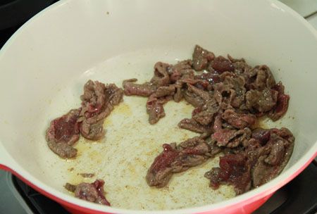 炒鍋倒少許油與麻油開火加熱，牛肉片加少許油與太白粉水拌勻放入快速炒至7分熟取出。