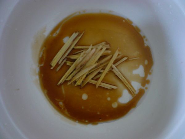 準備砂鍋，放入切成絲的薑和麻油。
(不使用砂鍋亦可，只是砂鍋的烹調效果較好，雞肉和香菇容易入味)