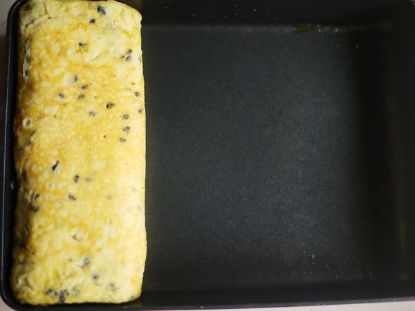 將卷好的蛋皮推至前面，再加入一點蛋液. 重複３－５步驟動作到蛋液用完