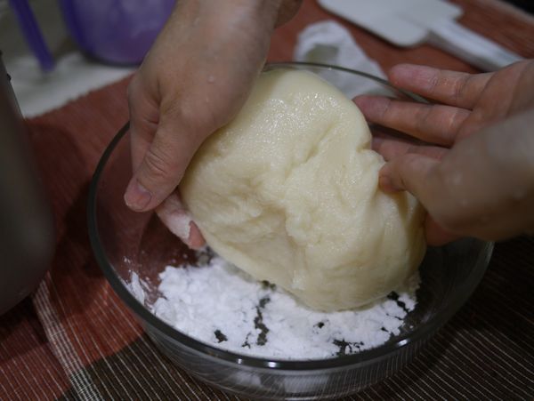 完成的麻糬，可在已經撒上太白粉的容器中，充份翻滾，便可準備搓成一團團。