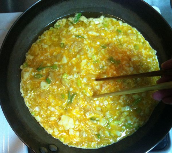 熱鍋熱油後轉成小火再將蛋汁倒入, 使用筷子輕輕地以順時鐘方向畫圓, 使材料平均分布, 厚薄一致.