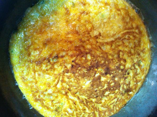 慢火細烘, 待底部呈金黃色澤微焦, 表面蛋液稍凝結後便可滑入大盤, 再倒扣回平底鍋煎另一面.