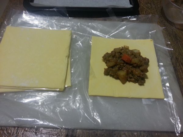 取一張酥餅皮中間放入一些餡料對角包起來